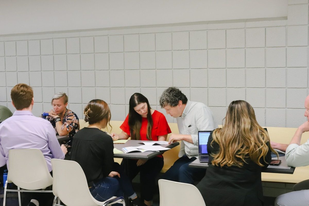 Law students and volunteer attorneys discuss legal issues like debt collection, housing, and employment during Street Law.