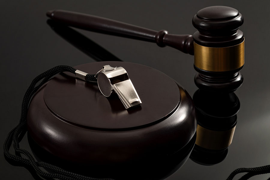  Metal whistle and wooden judge gavel on dark background.  