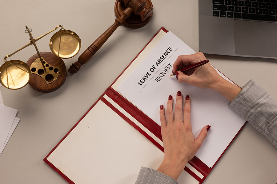 A woman fills out a blank leave of absence request for the Family and Medical Leave Act and the California Family Rights Act.