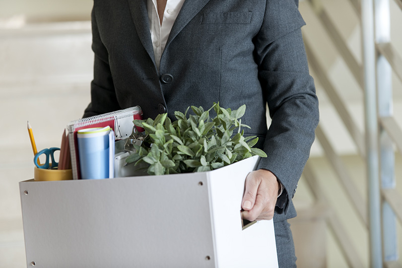 Man holding a box of office supplies walkin